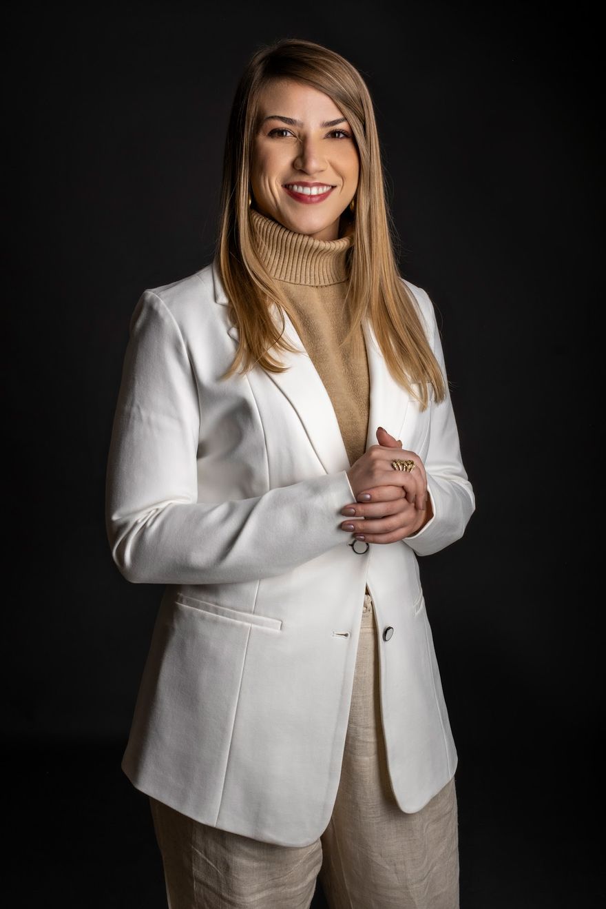 Retrato da Dra. Gabriela Figueiredo em estúdio, vestindo blazer branco